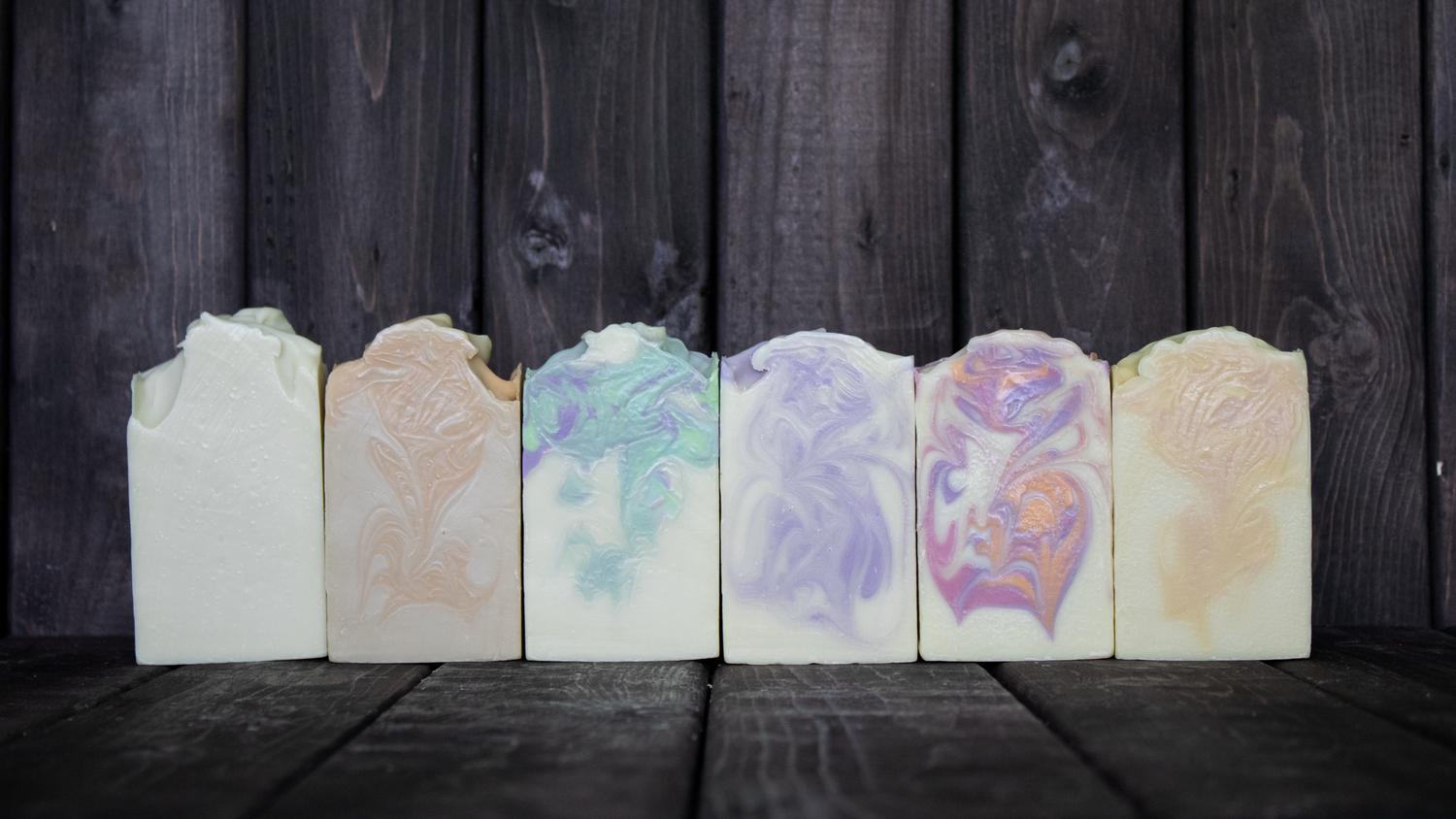 Colourful soap in front of a dark wood background.